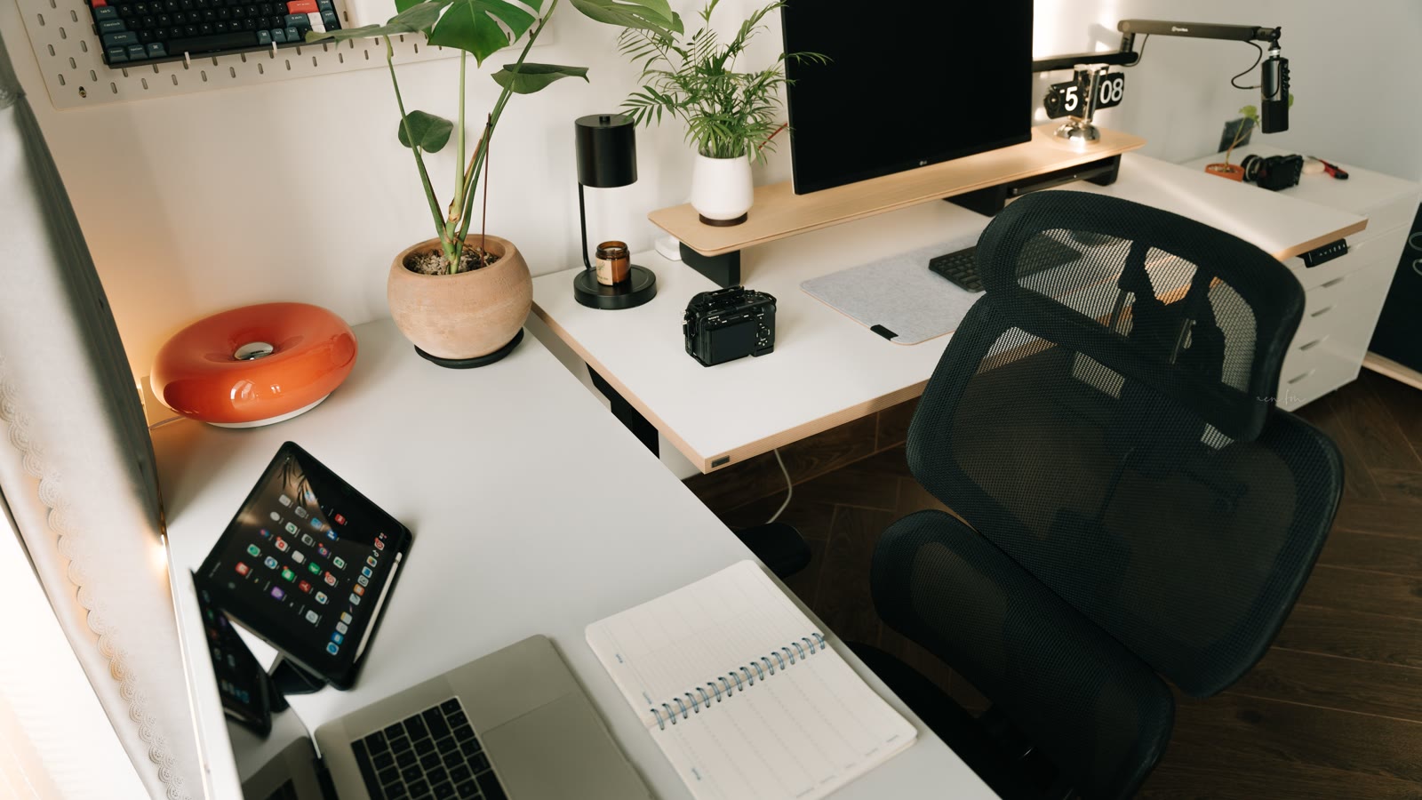 Hjemmearbejdsplads med computer, planter og skrivebordslampe