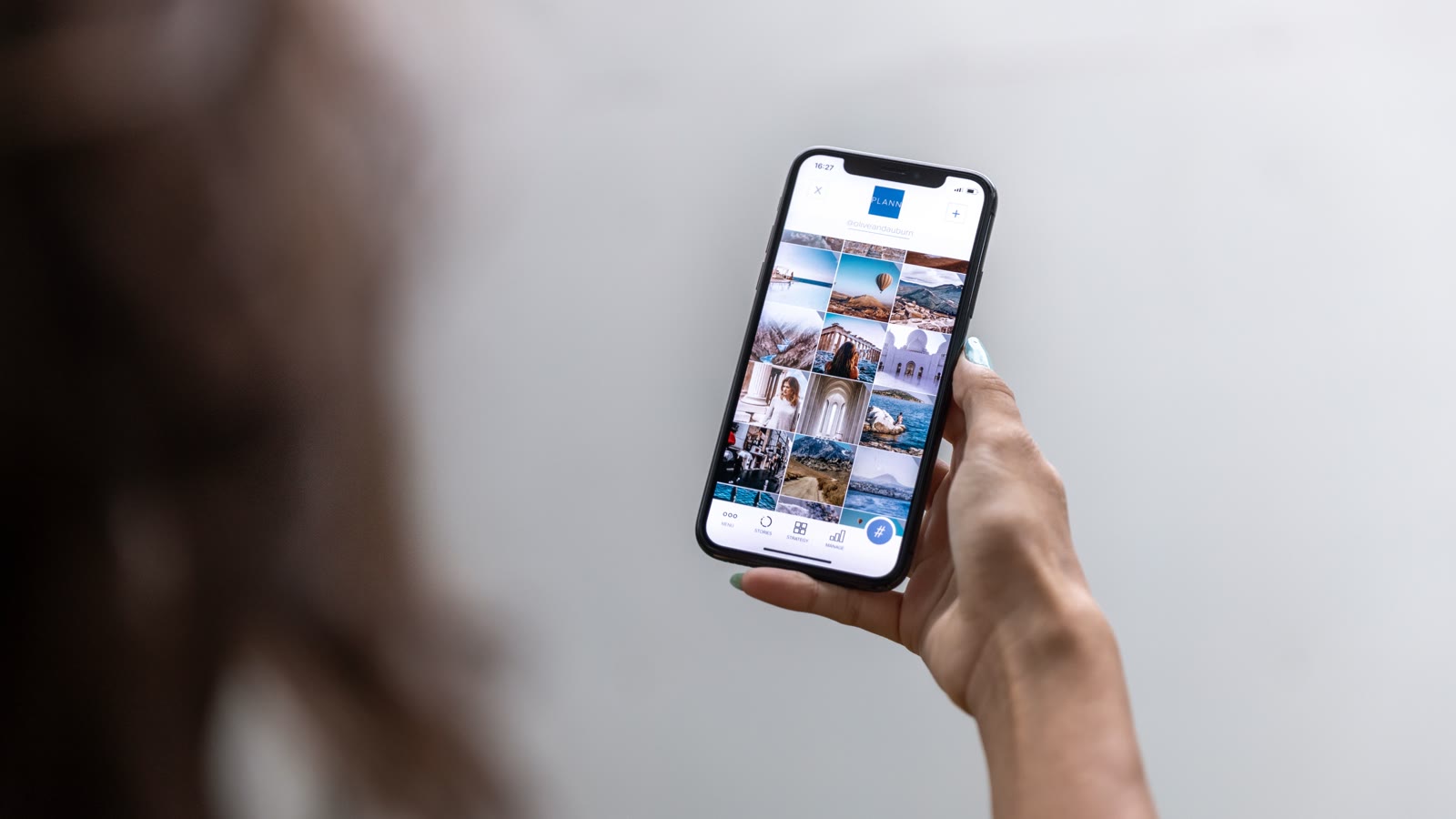 Kvinde holder en telefon med et socialt medie paa skaermen