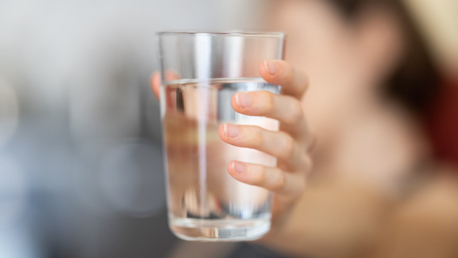 En hånd holder et glas koldt vand