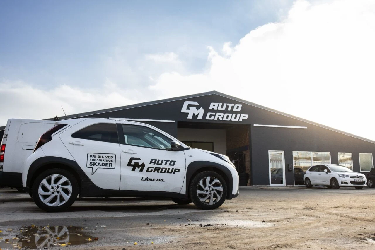 Facadeskilt med navnet GM Auto Group på en virksomhedsbygning